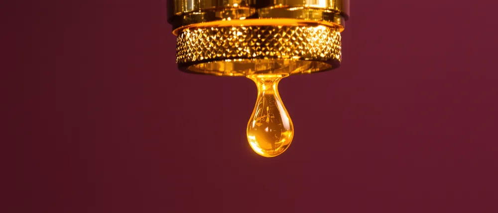 A molten gold bead dripping from a brass art deco pipe joint